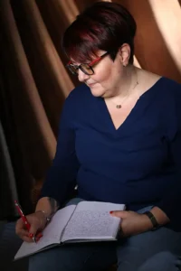 Femme concentrée écrivant dans un carnet, symbole de réflexion stratégique et de recentrage